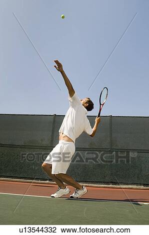 Man Serving Tennis Ball on tennis court View Large Photo Image Stock Image - Man Serving Tennis Ball on tennis court. Fotosearch