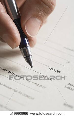 Stock Photograph - Man signing document close up of pen in hand. Fotosearch