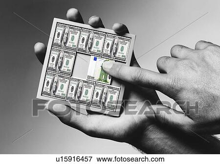 Stock Photo - Man solving economic puzzle. Fotosearch