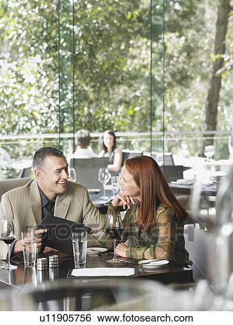 Stock Photograph - Man touching woman's chin at outdoor bar. Fotosearch