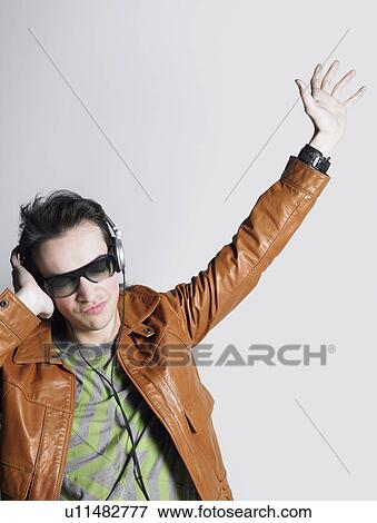 Stock Photo - Man wearing headphones and sunglasses head and shoulders. Fotosearch