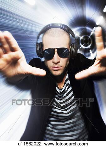 Man wearing headphones in front of tunnel effect view through hands View Large Photo Image Stock Image - Man wearing headphones in front of tunnel effect view through hands. Fotosearch