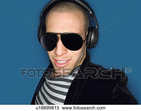 Stock Photography - Man wearing headphones in studio head and shoulders. Fotosearch