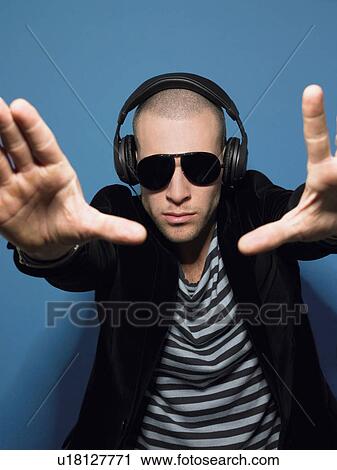Man wearing headphones in studio view through hands View Large Photo Image Stock Image - Man wearing headphones in studio view through hands. Fotosearch