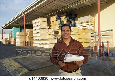 Man with clipboard outside warehouse full of wood View Large Photo Image Stock Image - Man with clipboard outside warehouse full of wood. Fotosearch