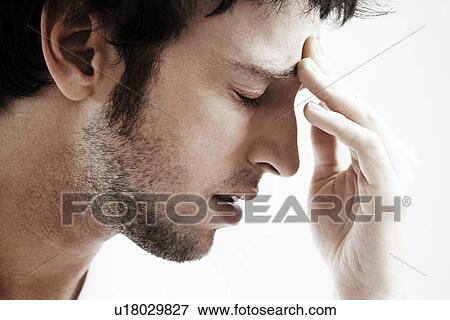 Stock Photo - Man with Headache touching forehead close up. Fotosearch