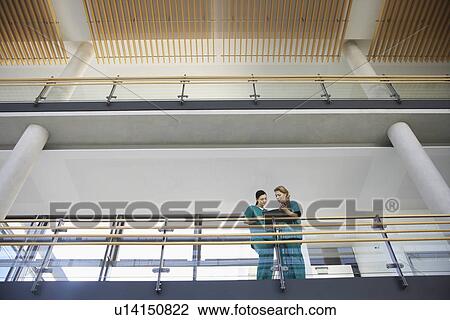 Medical workers looking at chart on balcony low angle view View Large Photo Image Stock Image - Medical workers looking at chart on balcony low angle view. Fotosearch