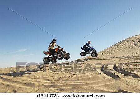 Men doing wheelies on quad bikes in desert View Large Photo Image Stock Image - Men doing wheelies on quad bikes in desert. Fotosearch