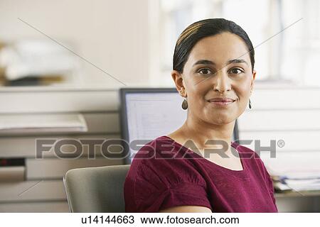 Mid-adult female office worker sitting in cubicle portrait View Large Photo Image Stock Image - Mid-adult female office worker sitting in cubicle portrait. Fotosearch