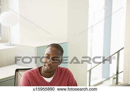 Mid-adult male office worker at desk contemplating View Large Photo Image Stock Image - Mid-adult male office worker at desk contemplating. Fotosearch