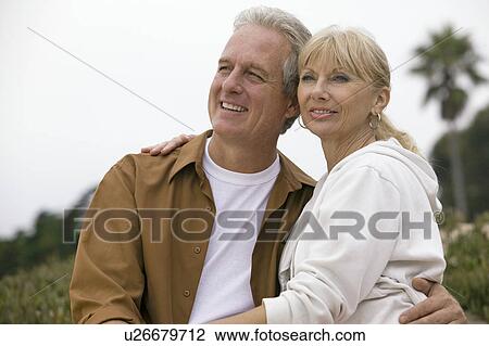 Stock Image - Middle-aged couple embracing. Fotosearch
