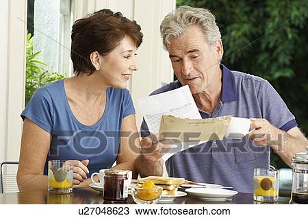 Middle-aged couple looking at bill over breakfast View Large Photo Image Stock Image - Middle-aged couple looking at bill over breakfast. Fotosearch
