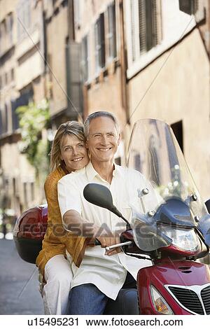 Middle-aged couple on scooter on street in Rome Italy portrait View Large Photo Image Stock Image - Middle-aged couple on scooter on street in Rome Italy portrait. Fotosearch