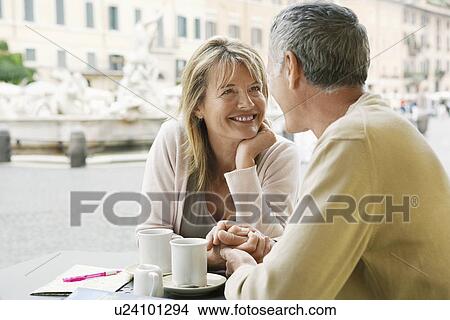 Picture - Middle-aged couple sitting at outdoor cafe in Rome close up. Fotosearch