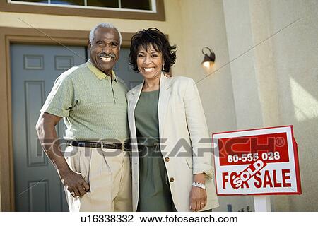 Middle-aged couple standing in front of new home portrait View Large Photo Image Stock Image - Middle-aged couple standing in front of new home portrait. Fotosearch