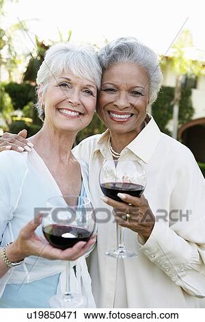 Middle-aged Friends standing outside Drinking Wine from wineglasses View Large Photo Image Stock Image - Middle-aged Friends standing outside Drinking Wine from wineglasses. Fotosearch