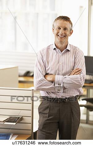 Middle-aged male office worker standing by cubicle portrait View Large Photo Image Stock Photograph - Middle-aged male office worker standing by cubicle portrait. Fotosearch