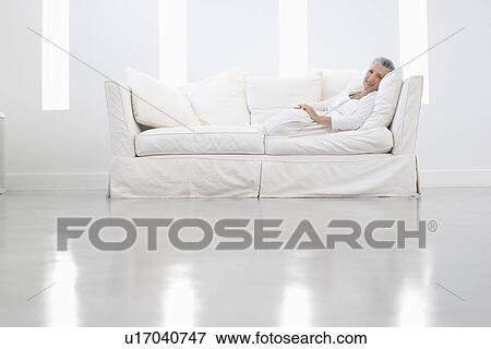 Middle-aged woman relaxing on sofa View Large Photo Image Stock Photo - Middle-aged woman relaxing on sofa. Fotosearch