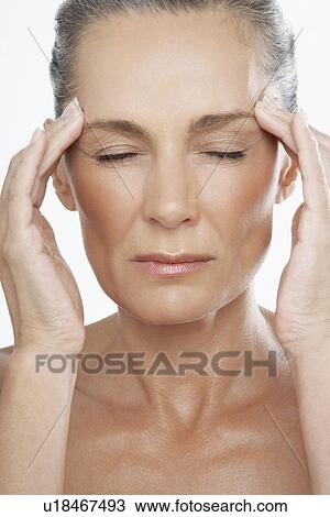 Middle-Aged Woman with fingers on forehead View Large Photo Image Stock Image - Middle-Aged Woman with fingers on forehead. Fotosearch