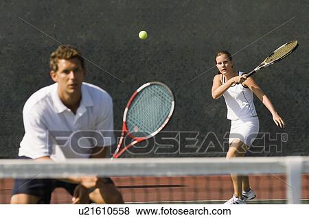 Mixed Doubles player hitting tennis ball partner standing near net View Large Photo Image Stock Photo - Mixed Doubles player hitting tennis ball partner standing near net. Fotosearch