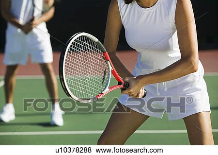 Mixed doubles tennis players on court focus on woman mid section View Large Photo Image Stock Photo - Mixed doubles tennis players on court focus on woman mid section. Fotosearch