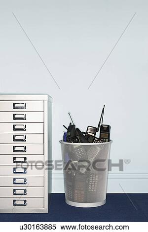 Mobile phones in trash can by filing cabinet View Large Photo Image Stock Photography - Mobile phones in trash can by filing cabinet. Fotosearch