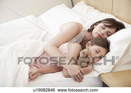 Mother and daughter sleeping in bed portrait View Large Photo Image Stock Photograph - Mother and daughter sleeping in bed portrait. Fotosearch