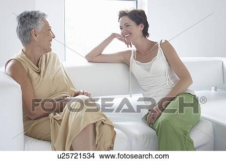 Picture - Mother and daughter talking on sofa in living room. Fotosearch