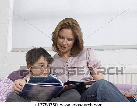 Mother and son (5-6) reading book on couch in living room View Large Photo Image Stock Image - Mother and son (5-6) reading book on couch in living room. Fotosearch