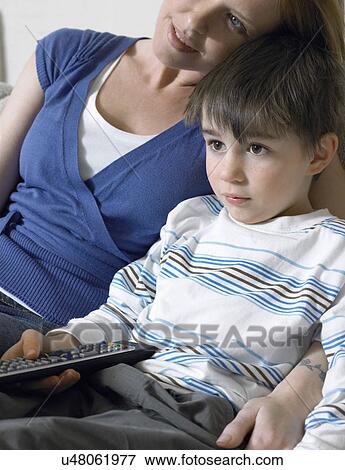 Mother and son (5-6) watching television on couch View Large Photo Image Stock Photo - Mother and son (5-6) watching television on couch. Fotosearch