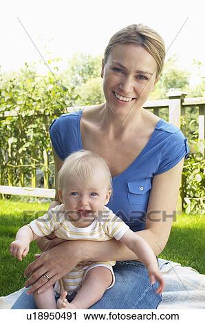 Mother and son sitting on rug in garden View Large Photo Image Stock Image - Mother and son sitting on rug in garden. Fotosearch