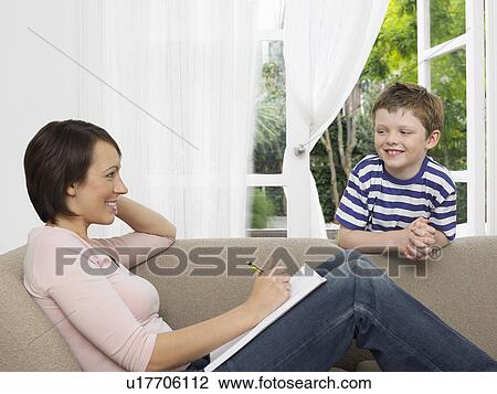 Mother and young son by couch View Large Photo Image Stock Image - Mother and young son by couch. Fotosearch