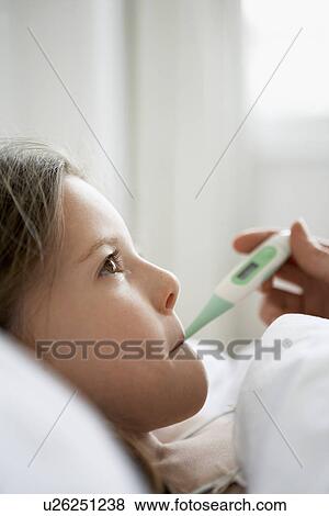 Mother checking temperature of daughter in bed close up of daughter View Large Photo Image Stock Photo - Mother checking temperature of daughter in bed close up of daughter. Fotosearch