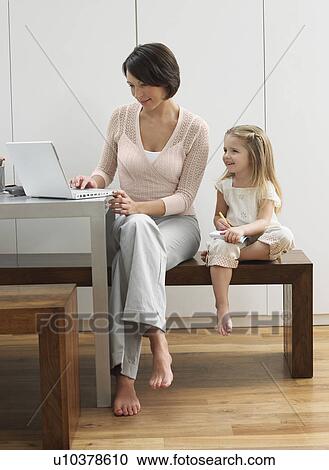Mother showing daughter laptop View Large Photo Image Stock Image - Mother showing daughter laptop. Fotosearch