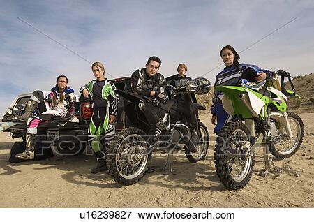 Motocross racers with bikes in desert (portrait) View Large Photo Image Stock Photo - Motocross racers with bikes in desert (portrait). Fotosearch