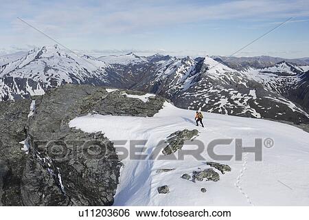 Mountain climber heading across snow for distant peak View Large Photo Image Stock Photograph - Mountain climber heading across snow for distant peak. Fotosearch