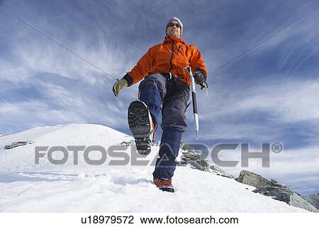 Mountain climber hiking on snowy slope View Large Photo Image Stock Image - Mountain climber hiking on snowy slope. Fotosearch
