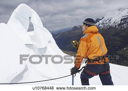Mountain climber holding compass near ice formation in snowy mountains View Large Photo Image Stock Photo - Mountain climber holding compass near ice formation in snowy mountains. Fotosearch