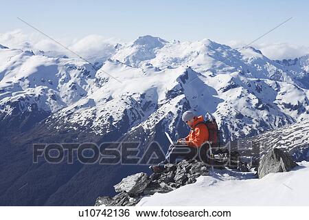 Mountain climber using laptop on mountain peak View Large Photo Image Stock Photograph - Mountain climber using laptop on mountain peak. Fotosearch