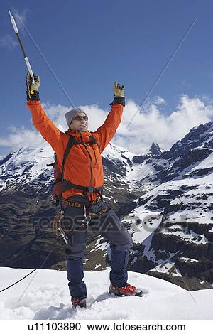 Mountain climber with arms raised on top of snowy peak View Large Photo Image Stock Image - Mountain climber with arms raised on top of snowy peak. Fotosearch