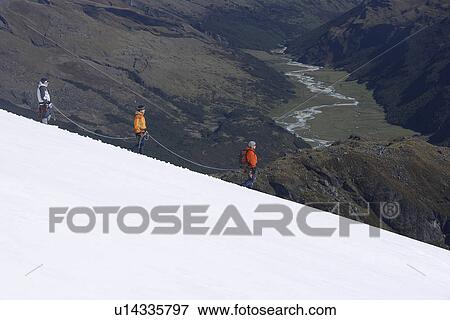 Stock Photo - Mountain climbers descending snowy slope. Fotosearch