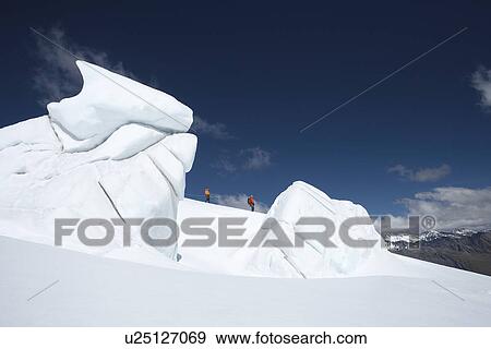 Mountain climbers walking past ice formation View Large Photo Image Stock Photo - Mountain climbers walking past ice formation. Fotosearch