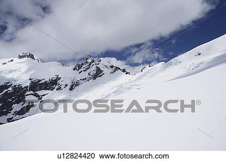 Stock Image - Mountain peaks beneath snow. Fotosearch