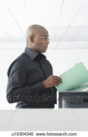 Office worker reading file in office side view View Large Photo Image Stock Image - Office worker reading file in office side view. Fotosearch