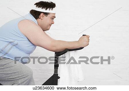 Overweight man on Exercise Bike side view View Large Photo Image Stock Image - Overweight man on Exercise Bike side view. Fotosearch