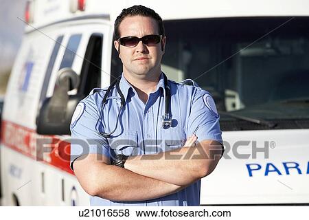 Paramedic worker standing in front of ambulance (portrait) View Large Photo Image Stock Photo - Paramedic worker standing in front of ambulance (portrait). Fotosearch