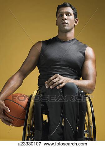 Paraplegic athlete sitting in wheelchair holding basketball View Large Photo Image Stock Photo - Paraplegic athlete sitting in wheelchair holding basketball. Fotosearch