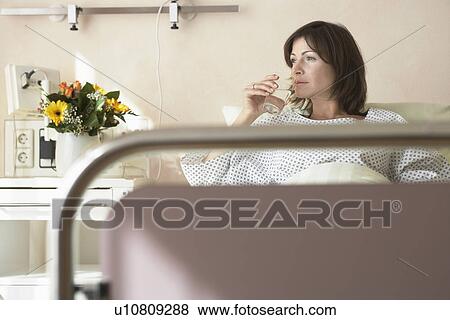 Stock Photo - Patient Drinking Water in Hospital Bed. Fotosearch