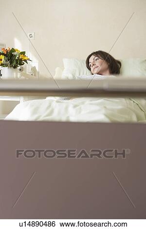 Stock Photograph - Patient Resting in Hospital Bed view from end of bed. Fotosearch