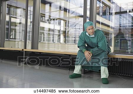 Pensive Physician sitting in hospital corridor View Large Photo Image Stock Photography - Pensive Physician sitting in hospital corridor. Fotosearch